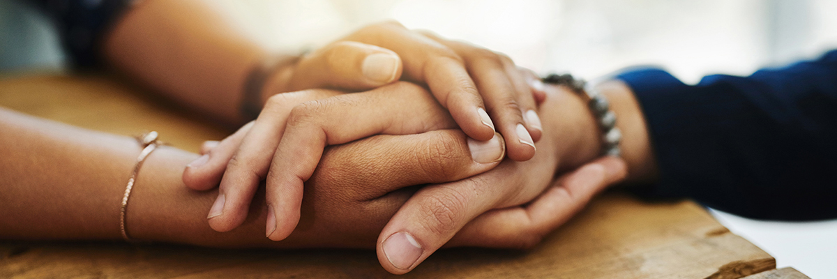 Two hands holding compassionately