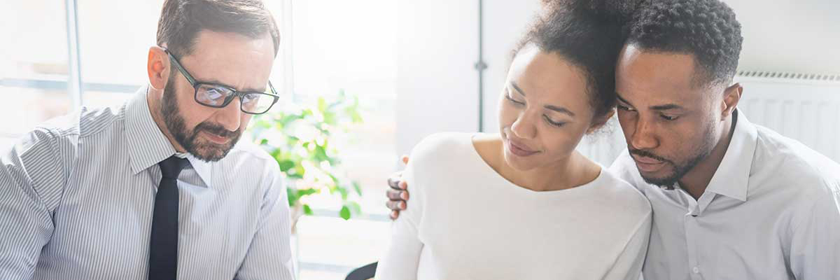 A staff member sitting with a young couple